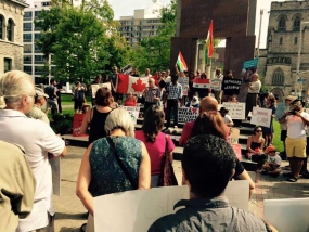 Hundreds gathered in Ottawa for the Refugees Welcome Rally on September 5th. An issue which caused some controversy during the event was the presence of a Syrian flag (visible in this photo). There are currently two versions of the Syrian flag. One associated with the Assad regime, which is the one if the photo, and is red, white, black with two green stars. There other flag adopted by Syrian oppositions groups is green, white, and black with three red stars