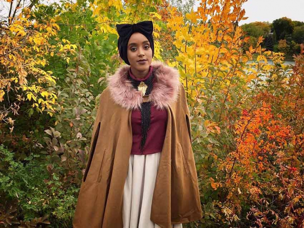 Fashion designer Eman Idil Bare is headed to New York Fashion Week. In this photo, she sports a handmade velvet turban and cape from her own fashion line