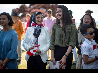 Maryam Sadat Montajabi, centre left, and her daughter Romina Khaksar, 15, who both moved to Canada from Iran in 2015, wait to have their photo taken with dignitaries after becoming Canadian citizens during a special Canada Day citizenship ceremony, in West Vancouver on July 1, 2019.