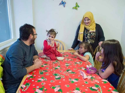 Syrian refugee family Mohammad Al Mnajer and wife Fouzia Al Hashish sit with their three daughters Judy, second left, Jaidaa, far right, and Baylasan as they eat their after school snack at their home in Mississauga, Ont., in December 2018.
