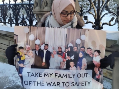 A Gazan Canadian holds a picture of her family at the 3 Day Vigil held on Parliament Hill.