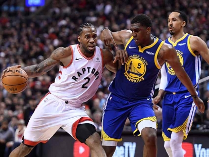 Toronto Raptors forward Kawhi Leonard drives up court as Golden State Warriors centre Kevon Looney defends during second half basketball action in Game 1 of the NBA Finals. THE CANADIAN PRESS/Frank Gunn