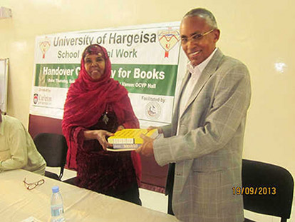 Asha Abdi Roobleh, President of Professional Social Workers Association is handing over books to the Honorable Minister of National Planning and Development Dr. Sa&#039;ad Ali Shire. Dr Sa&#039;ad is also the president of the Senate of the University of Hargeisa.