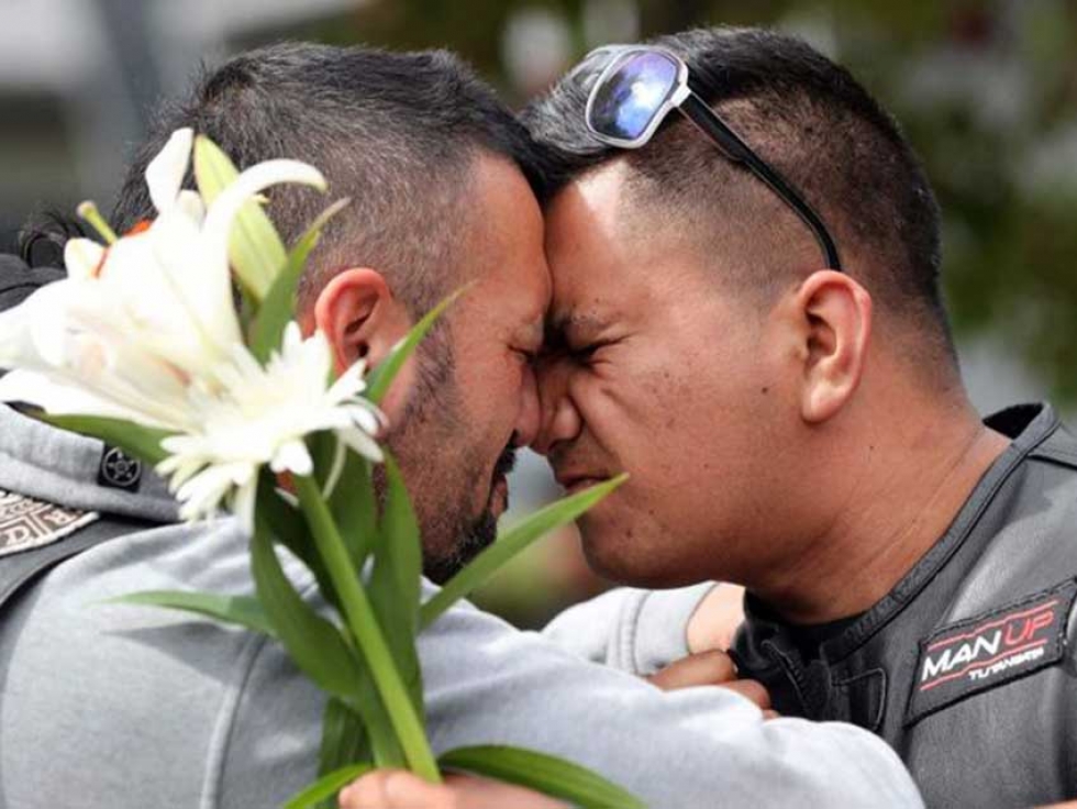 Mourners use the Maori traditional greeting or hongi at Hagley College on Saturday after the mosque attacks in Christchurch, New Zealand.