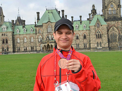 Bachar Awneh with his bronze medal in front of the Parliament Buildings.