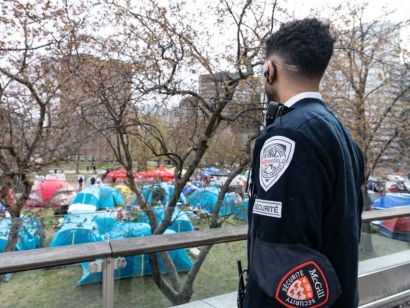 A McGill University security guard looks out at the pro-Palestinian encampment set up on the university campus in Montréal on April 29, 2024.