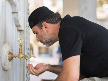 A Muslim man prepares for prayer by doing a ritual washing.