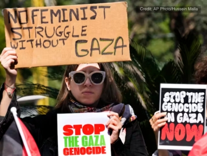 A woman holds placards at a protest outside a United Nations office in support of Palestinian women on International Women’s Day, in Beirut, Lebanon, March 8, 2024
